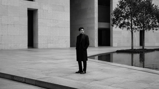 Homme seul dans une place minimaliste en noir et blanc, symbole de rareté, de retenue et de présence maîtrisée Mindset Ambition