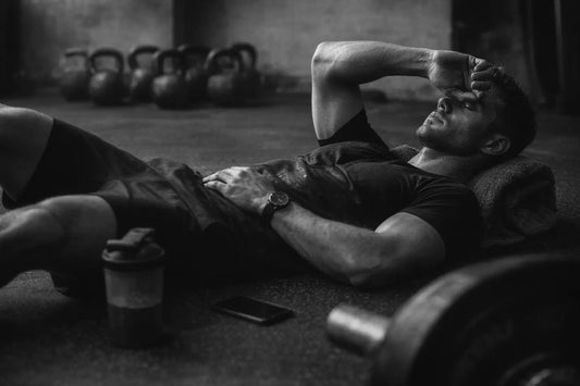 Homme allongé après l’effort physique, illustrant le repos stratégique et la récupération mentale nécessaire à la performance durable