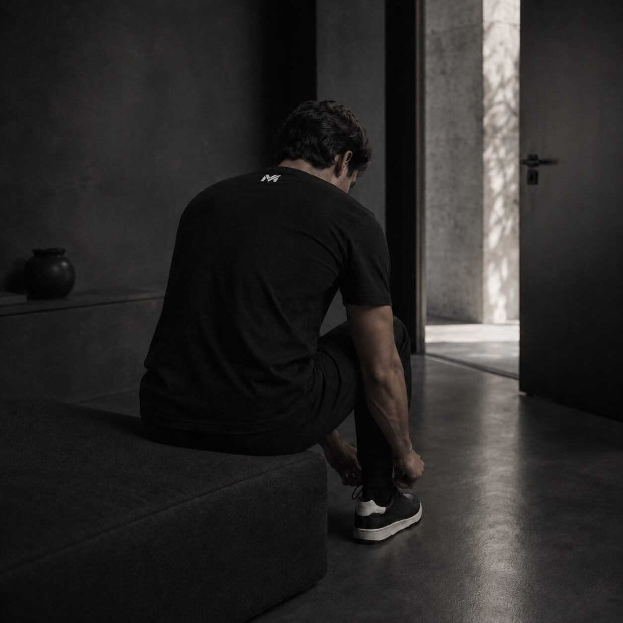 Homme en t-shirt noir Mindset Ambition dans une scène de préparation silencieuse Origine & Intention
