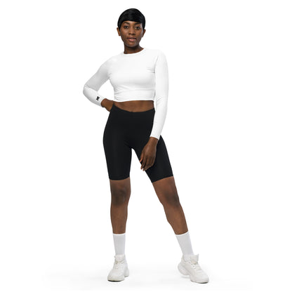 Haut de sport Evolve Mindset Ambition, blanc et logo noir sur le poignet droit, porté avec short noir, matière recyclée extensible, col surpiqué et coupe moderne – Mindset Ambition