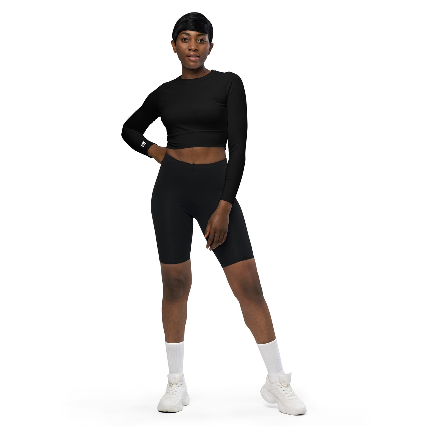Haut de sport Evolve Mindset Ambition, noir et logo blanc sur le poignet droit, porté avec short de sport noir, tissu extensible recyclé, design ergonomique et durable – Mindset Ambition