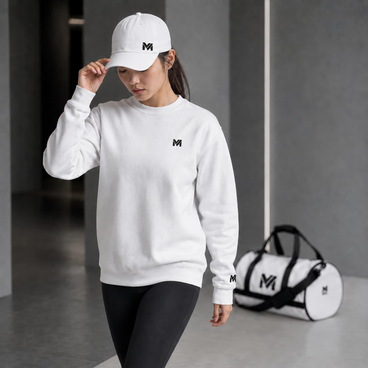 Illustration de la collection Détail & Élégance avec femme portant une casquette blanche, sweat blanc et sac de sport blanc en arrière-plan dans une ambiance premium Mindset Ambition