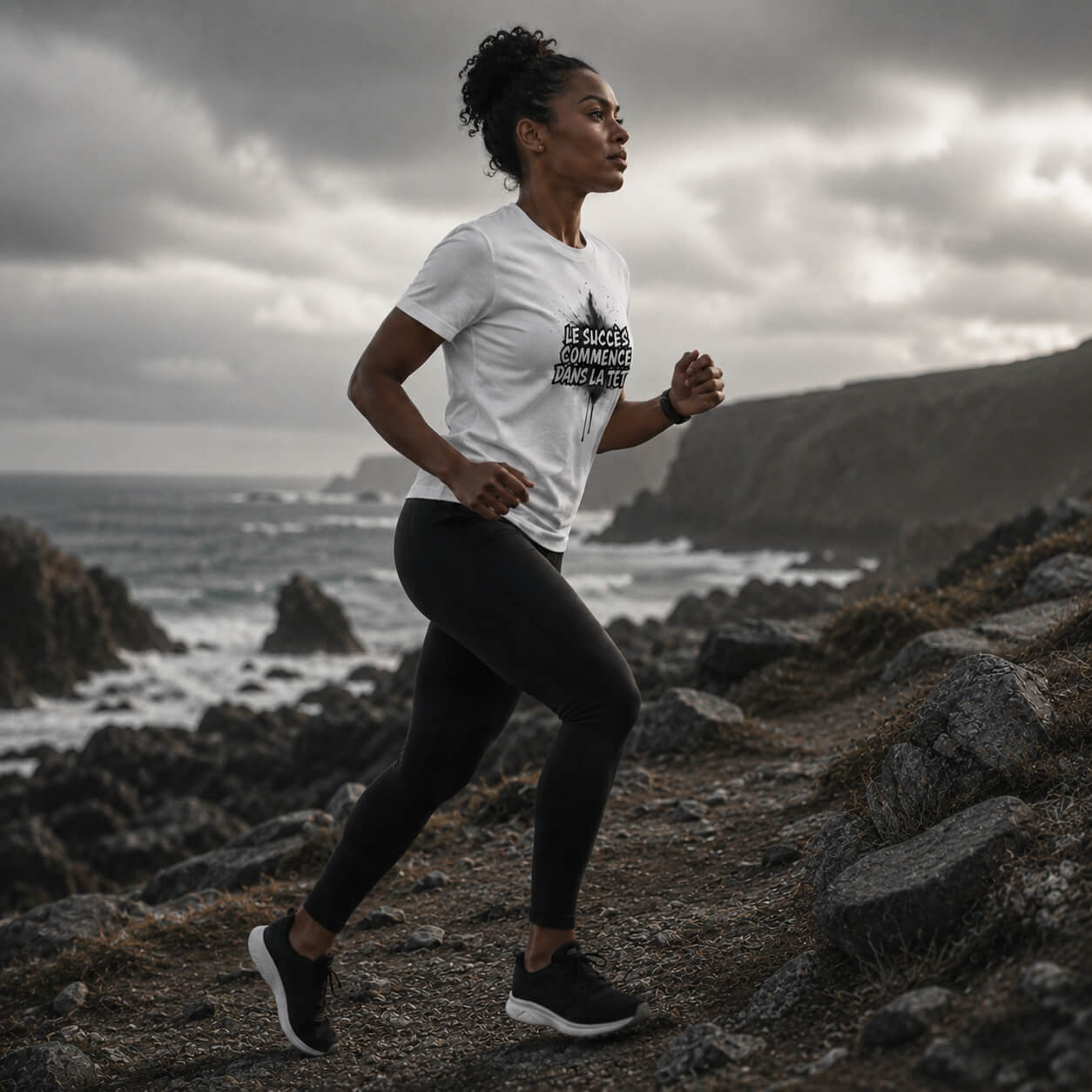 Femme en t-shirt blanc Mindset Ambition en course sur côte rocheuse Motivation & Performance