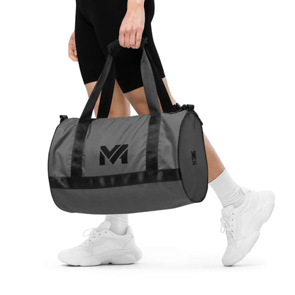 Sac de sport Smart Move Mindset Ambition, gris, porté à la main, logo noir centré sur le côté.